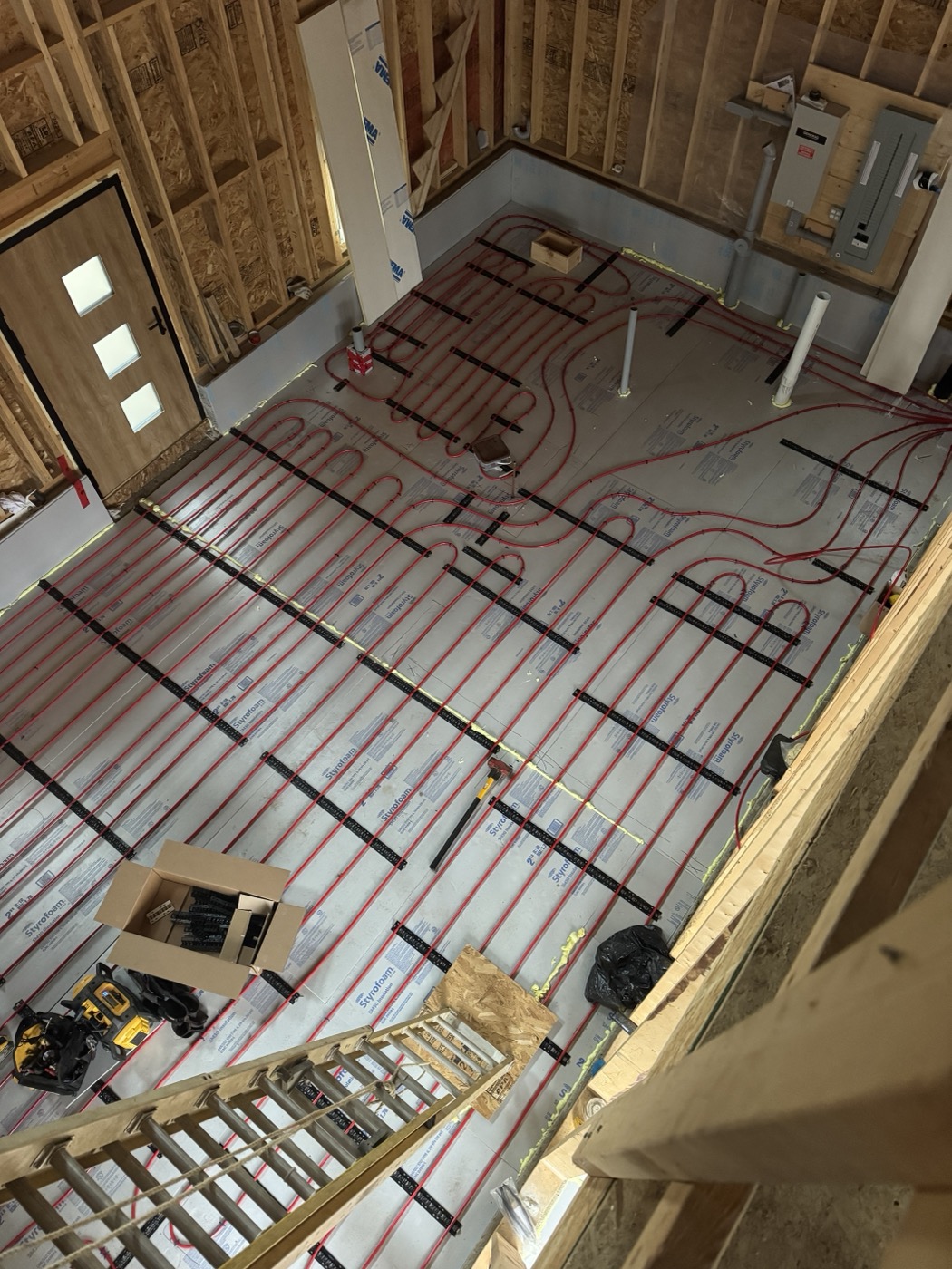 Radiant in-floor PEX tubing laid out on a new-build subfloor